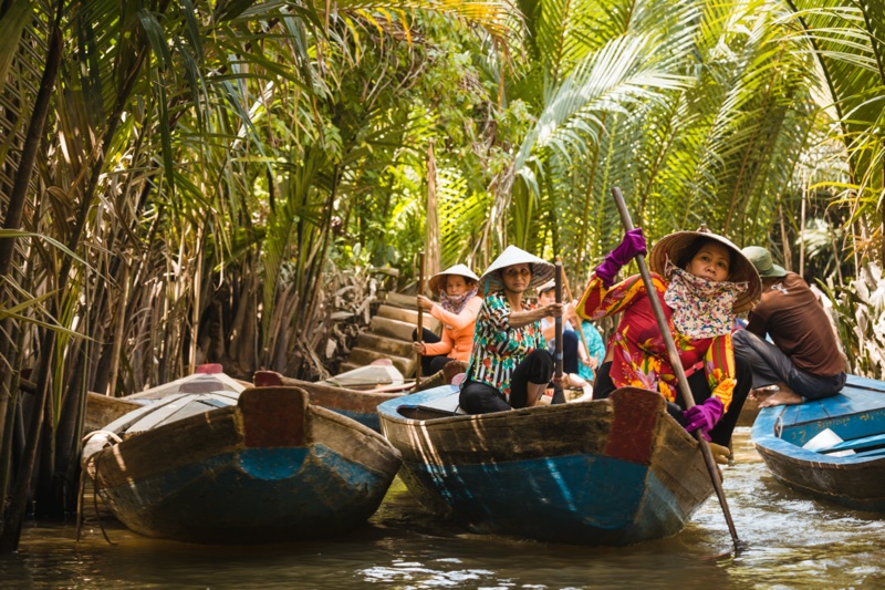 Women working paddling boats with tourists on the Mekong River